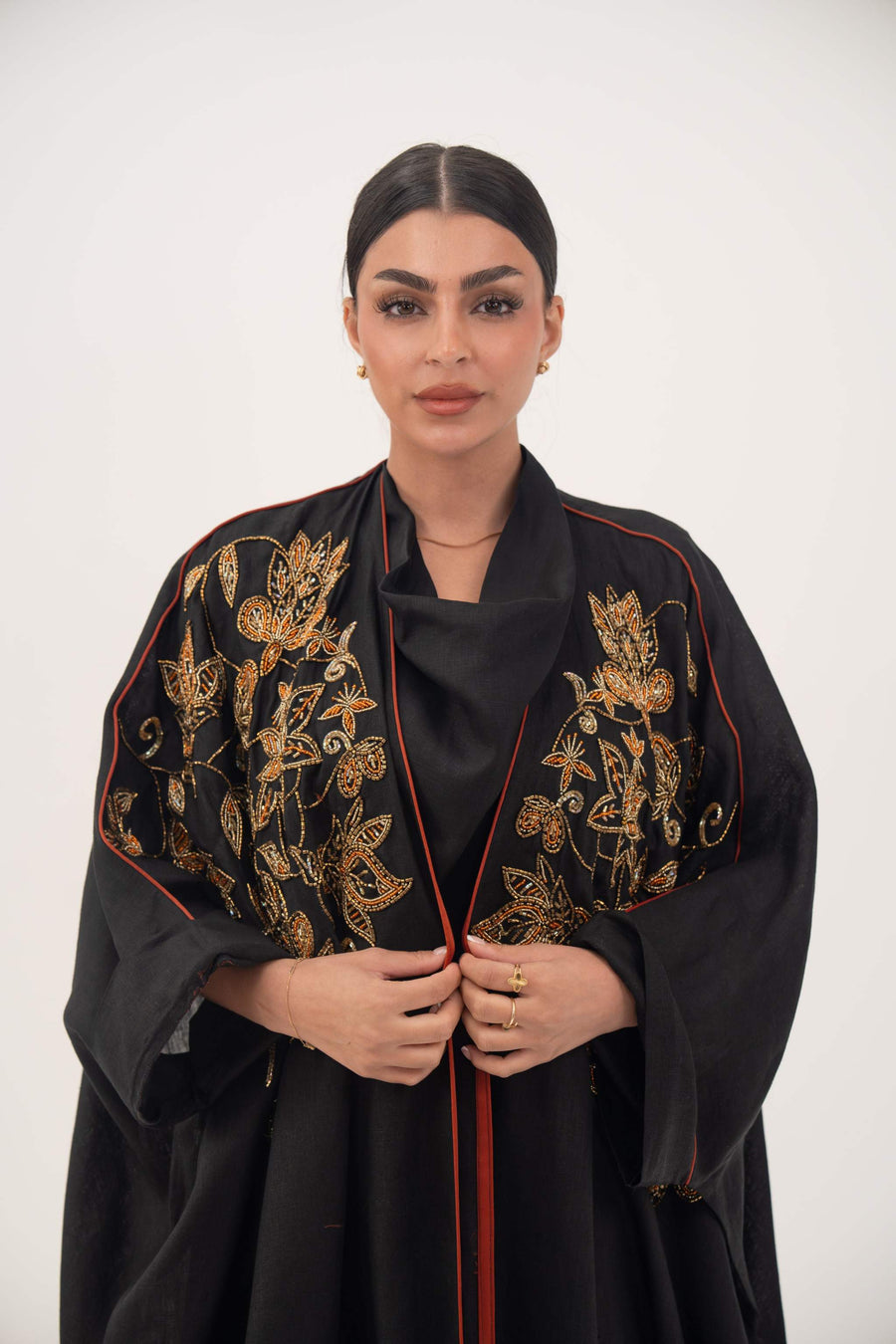 Black linen bisht abaya with golden and bronze shak embroidery and orange trim on model