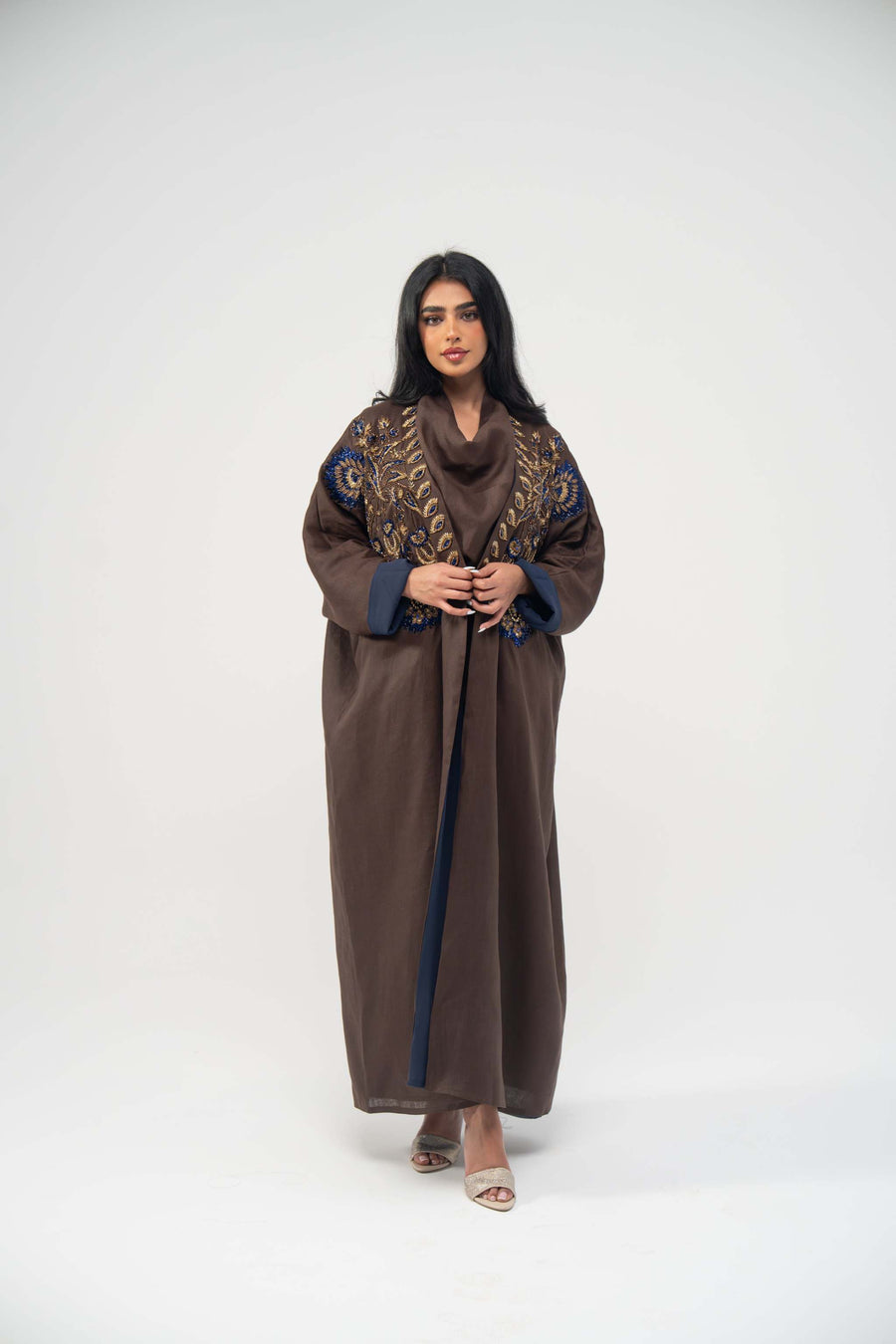 Elegant brown linen bisht abaya with navy blue chiffon lining and gold embroidery on the front.
