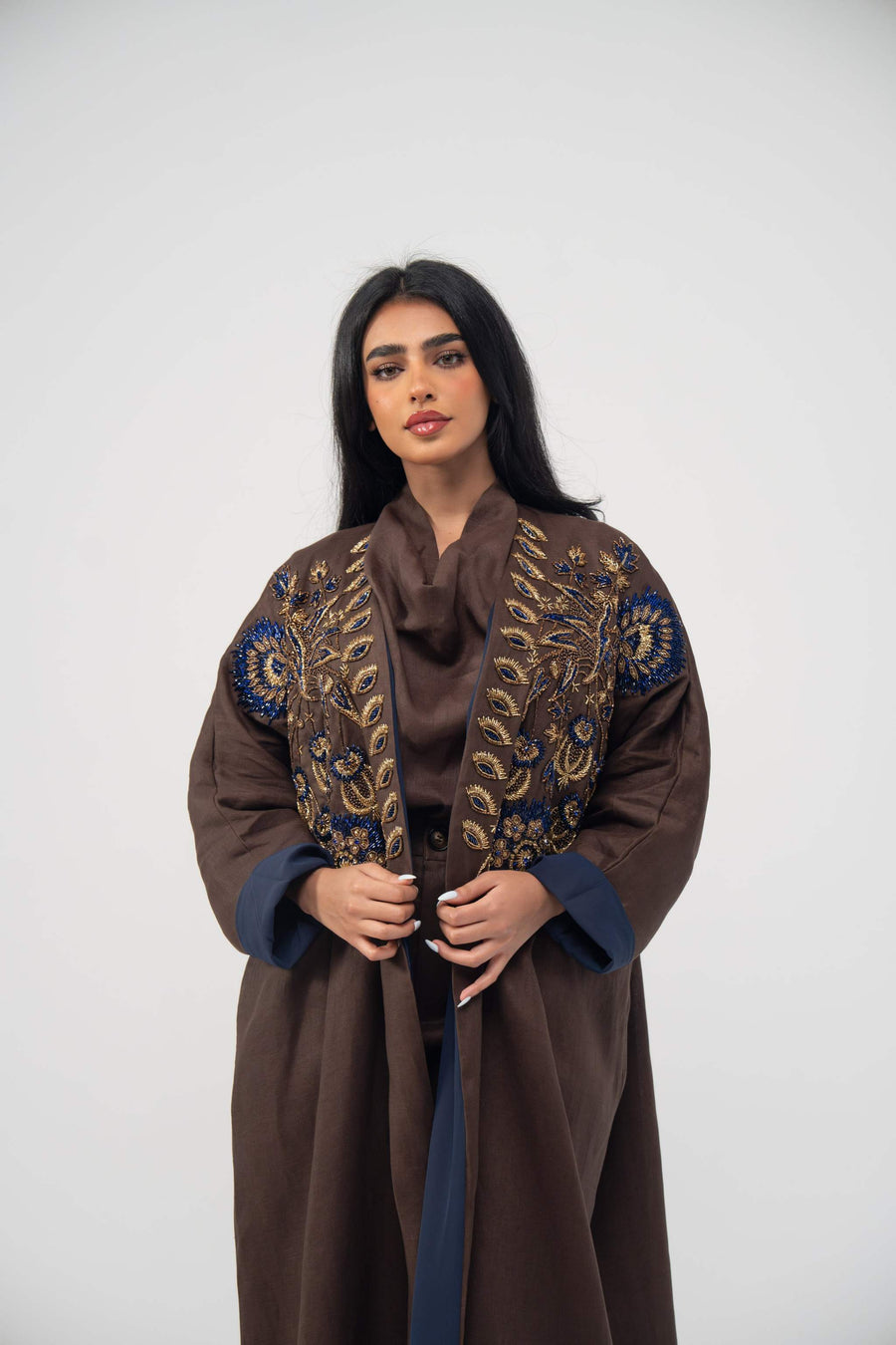 Elegant brown linen bisht abaya with navy blue chiffon lining and gold embroidery on the front.