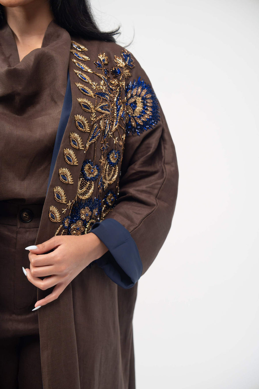 Brown linen bisht abaya with navy blue chiffon lining and intricate navy and gold embroidery on the front.