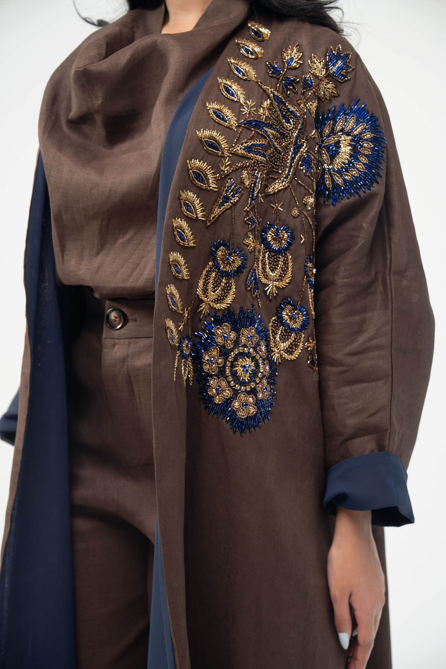 Elegant brown linen bisht abaya with navy blue chiffon lining and intricate navy and gold embroidery on the front.
