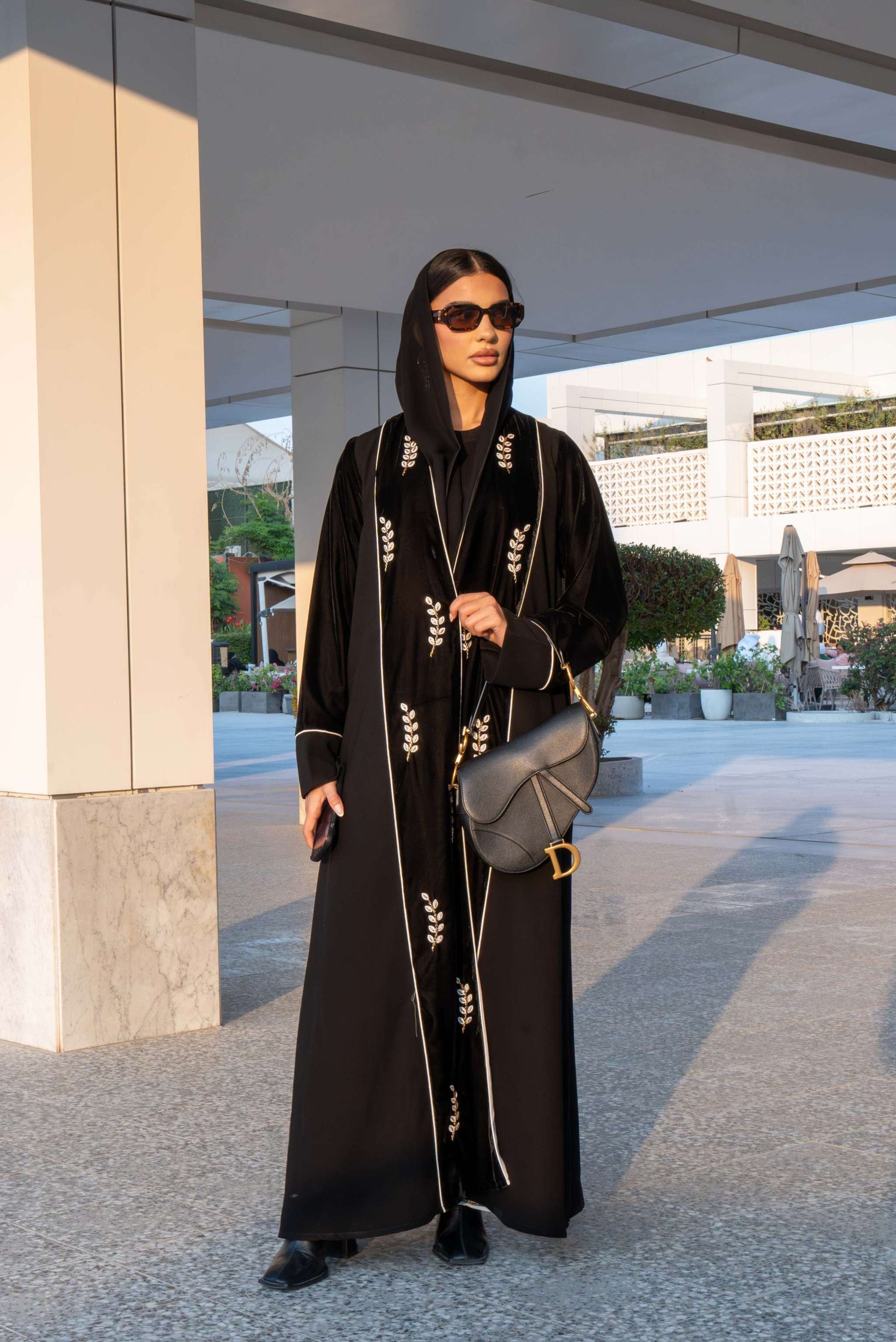 Elegant black Veloura Abaya with gold embroidery and velvet accents, perfect for special occasions.