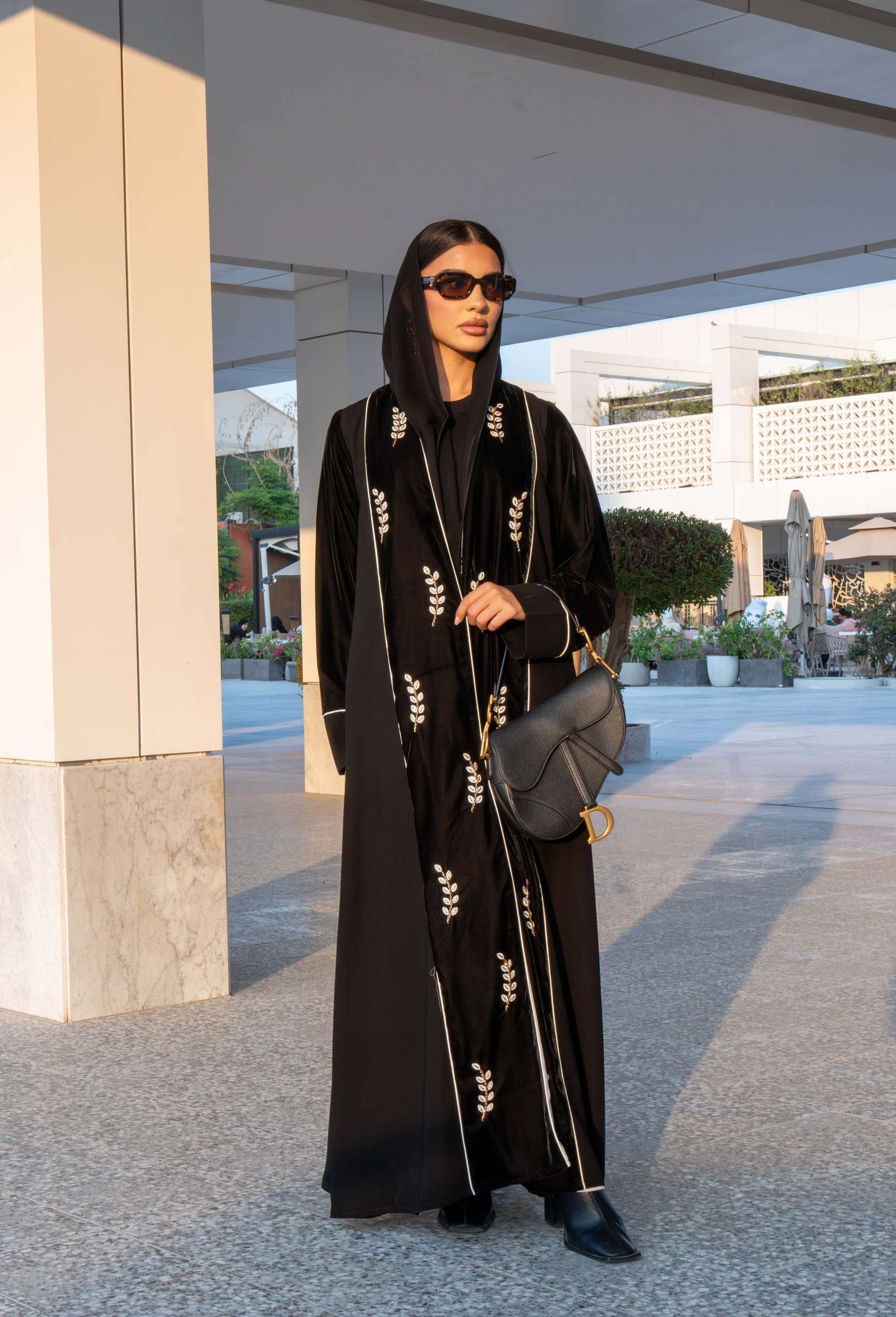 Elegant black Veloura Abaya with gold embroidery and velvet accents, perfect for special occasions.