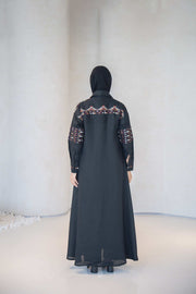 Full-length black linen abaya with traditional multicolor embroidery on back, sleeves, and shoulders.