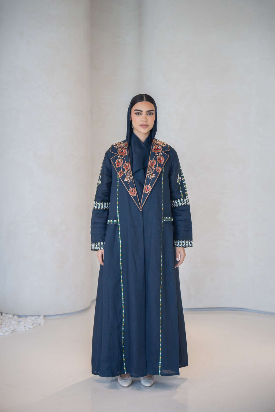Navy blue breathable lightweight linen abaya with colorful floral hand-embroidery and structured notched lapel collar.