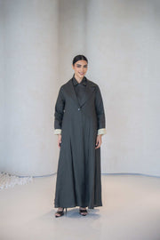 Charcoal gray blazer style abaya with classic collar, front buttons, pastel yellow cuff lining, and side pocket in lightweight linen.