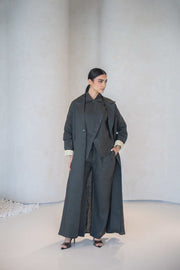 Woman wearing charcoal gray blazer-style abaya with pastel yellow cuff lining and side pocket in modern lightweight linen fabric