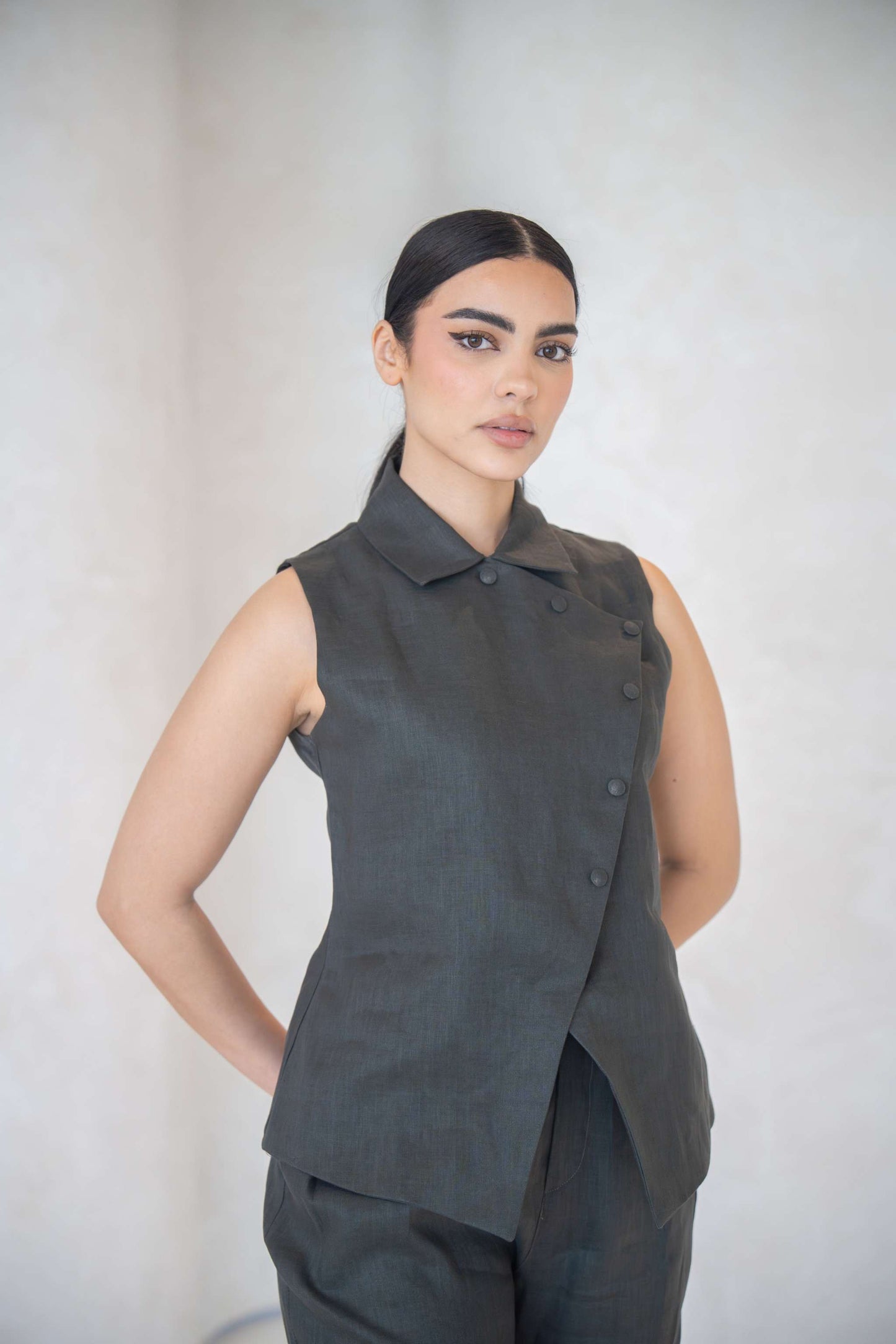 woman wearing charcoal gray vest with asymmetrical button front and collar