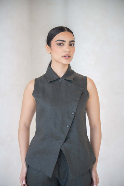 Woman wearing charcoal gray vest with asymmetrical buttoned front and shirt collar.