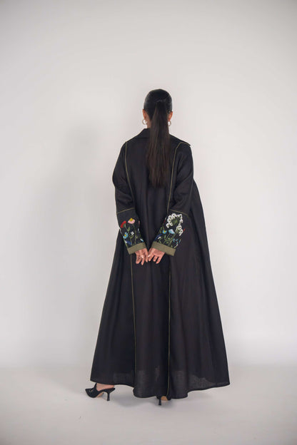 back view of black abaya with embroidered sleeves and olive green box pleats
