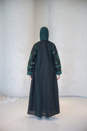 Black Zamurd abaya with green geometric embroidery, lightweight linen fabric, flowing bottom, and soft chiffon lining.