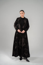 Woman wearing Black Jaguar velvet floral textured long blazer abaya with tailored lapels and sleek silhouette