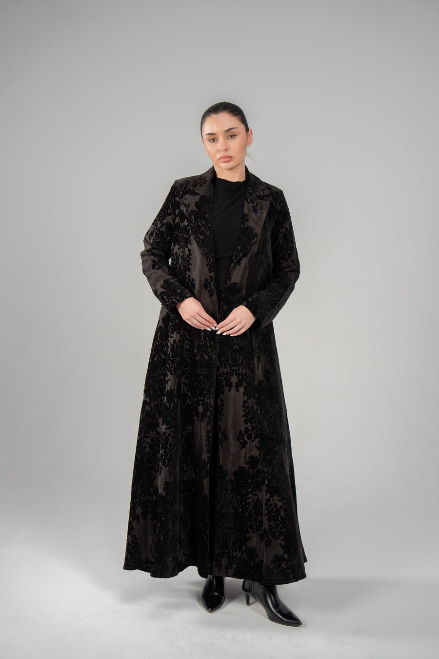 Woman wearing Black Jaguar velvet floral textured long blazer abaya with tailored lapels and sleek silhouette