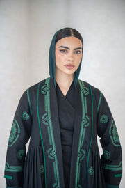Black Zamurd abaya with green geometric embroidery on front, sleeves, and shoulders, lightweight linen with soft chiffon lining.