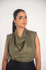 Woman wearing an olive green Raya blouse made of lightweight 100% linen with a relaxed fit and draped neckline.