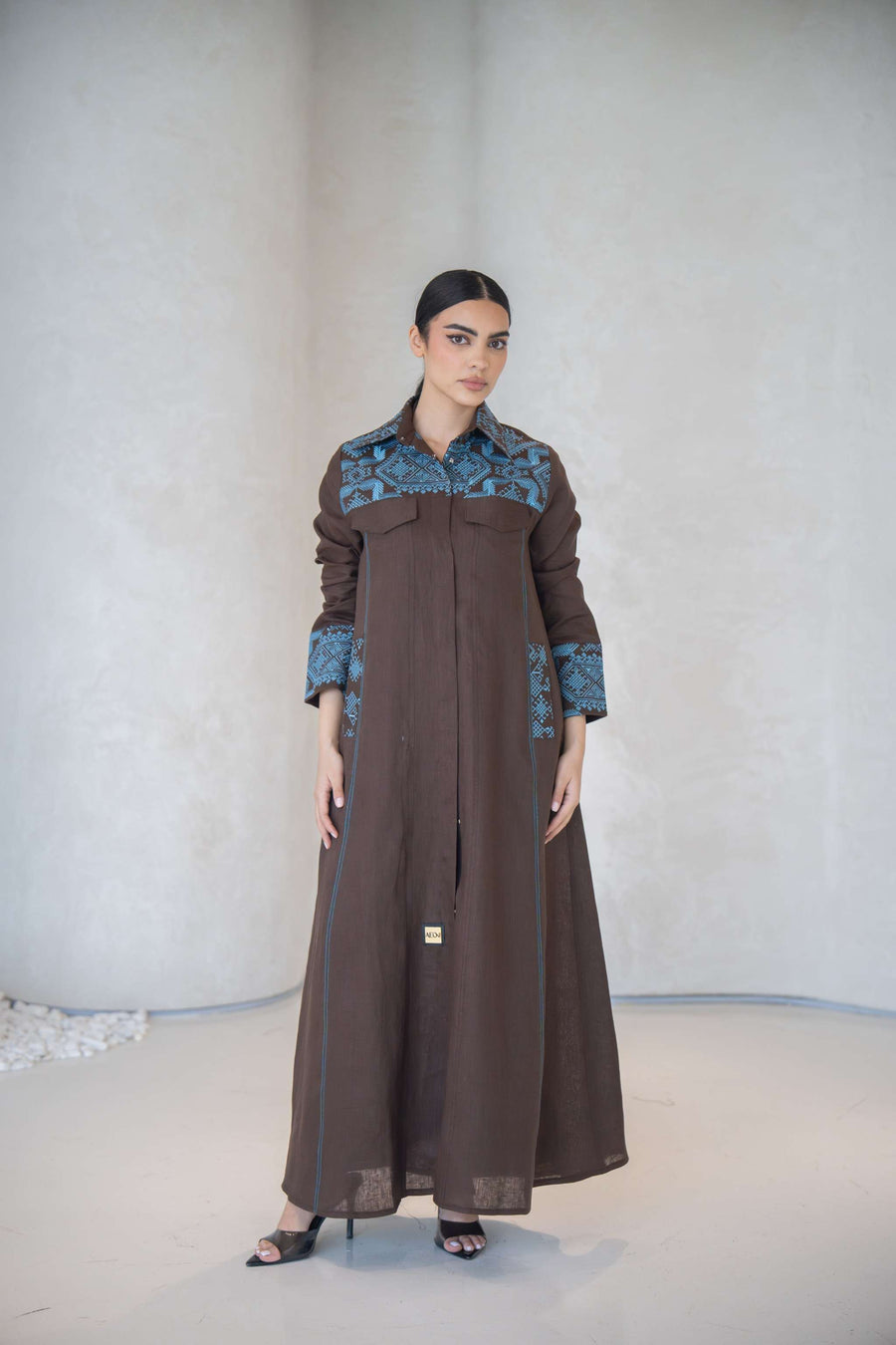 Elegant brown abaya with vertical blue embroidery and faux flap pocket, lightweight and comfortable for daily and special occasions abaya in a calm brown