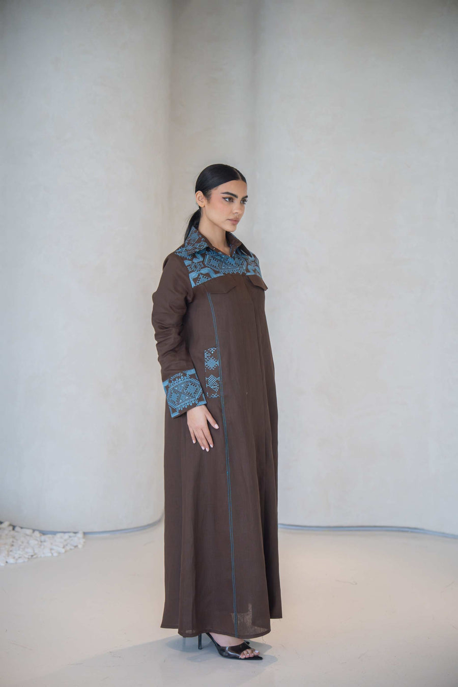 Elegant brown abaya with vertical turquoise embroidery and faux flap pocket, made from lightweight soft fabric, perfect for daily wear and special occasions abaya in a calm brown