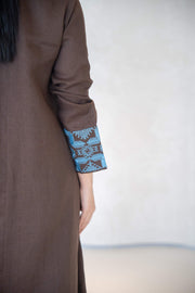 Close-up of brown abaya sleeve with vertical blue embroidery and faux flap pocket detail abaya in a calm brown