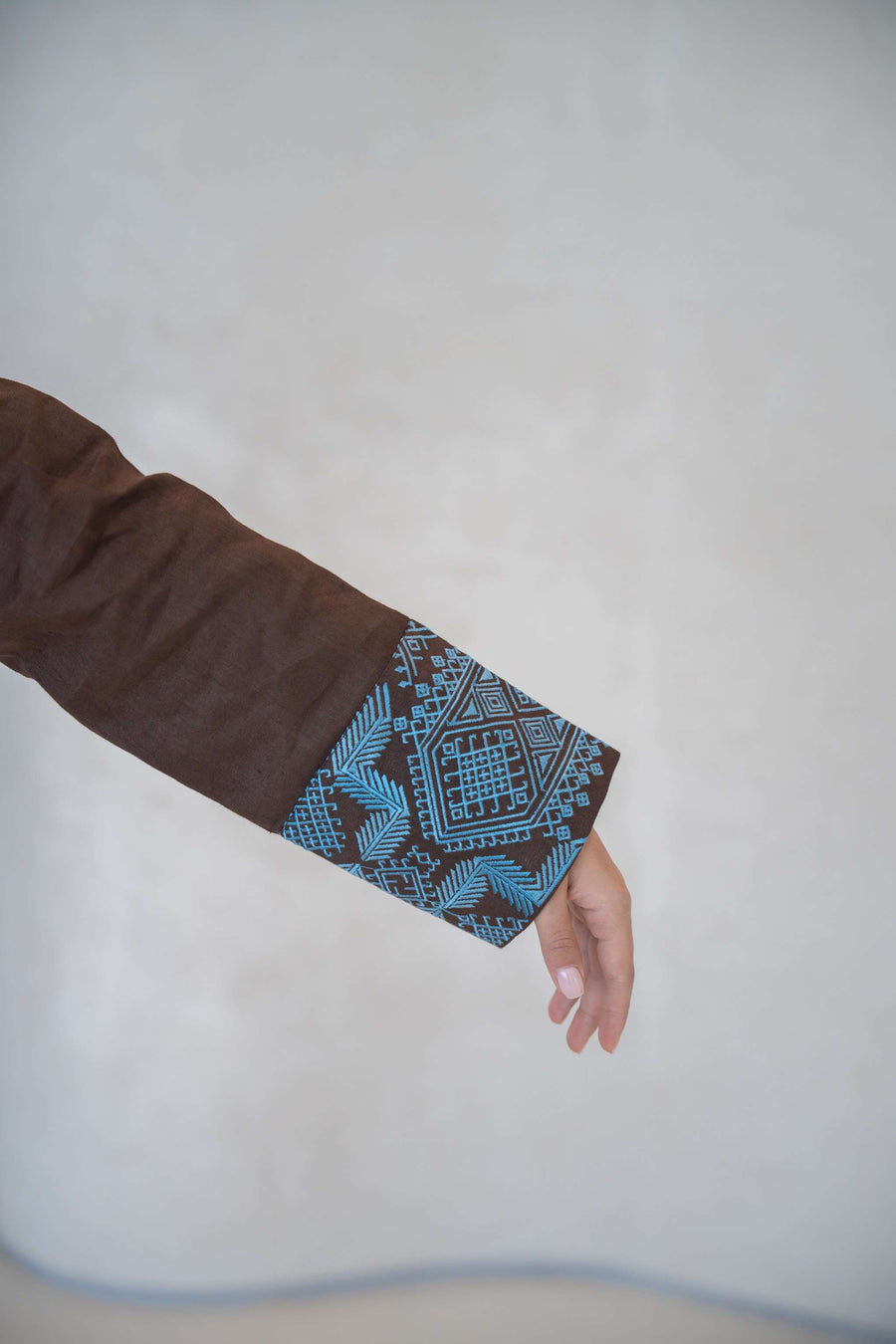 Brown abaya sleeve with vertical blue embroidered patterns and a stylish faux flap pocket detail abaya in a calm brown