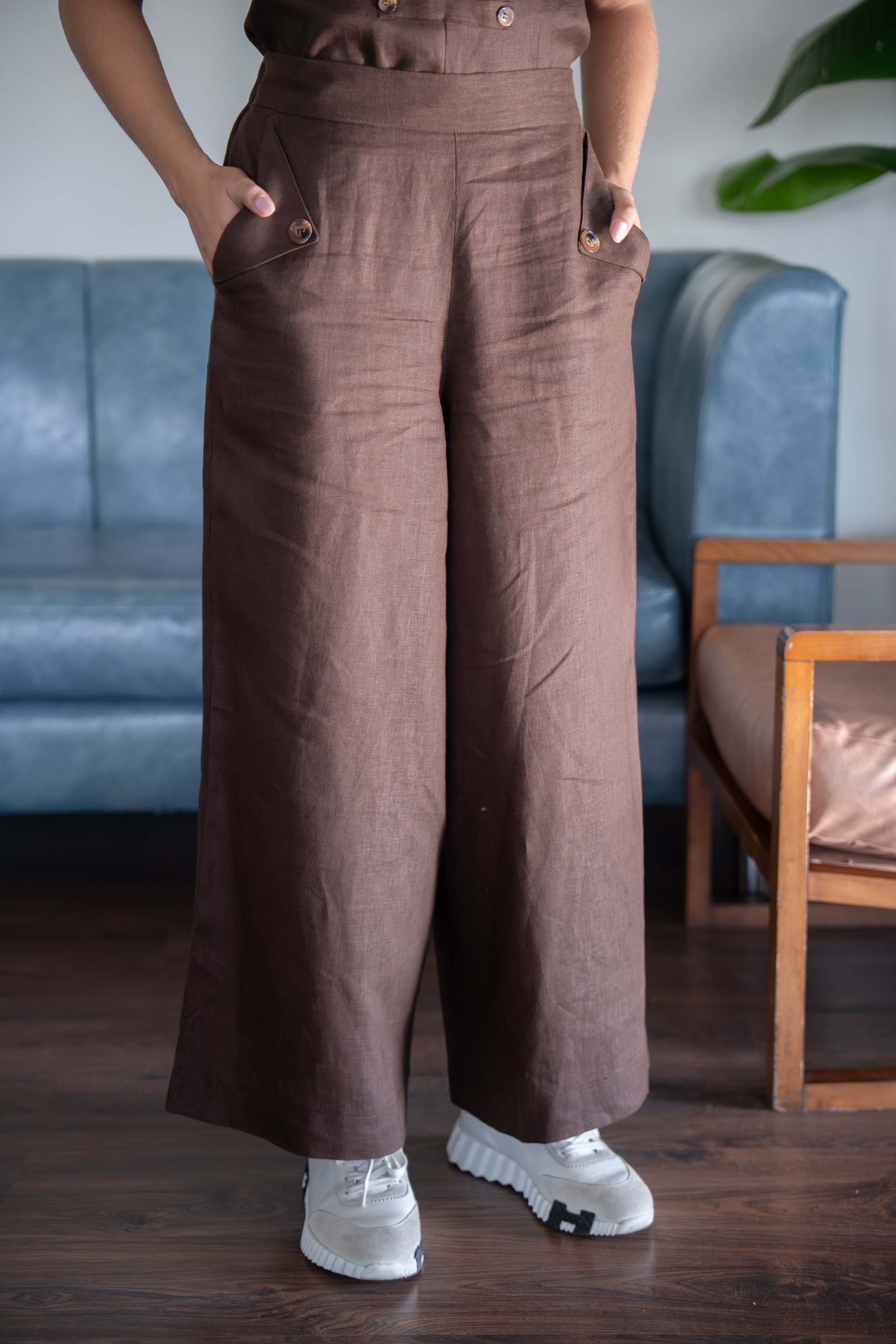 high-waisted brown wide-leg pants with flap pockets and button details in a polished structured fabric