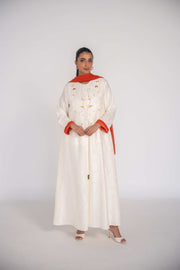 Elegant abaya made of textured jacquard fabric with hand-embroidered orange slice motifs and orange chiffon lining