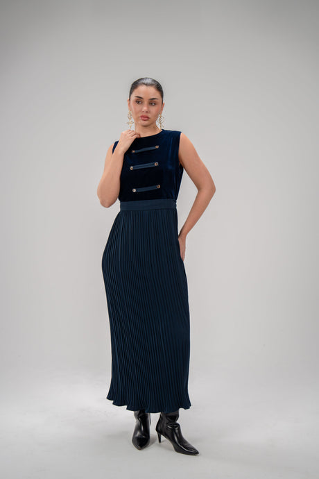Woman wearing a refined navy blue velvet top dress with pleated crepe skirt and button details