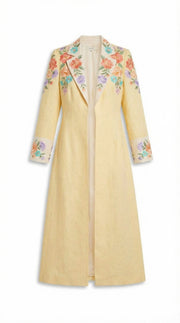 Yellow coat with floral embroidery on a white background