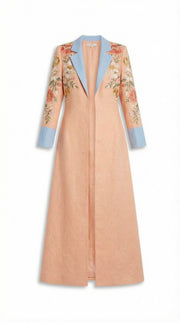 Long peach coat with floral sleeves and blue accents on a white background