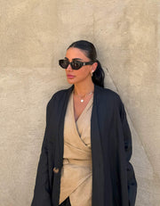 Minimalist black linen abaya with straight cut and open front, featuring subtle stitching and a flowy silhouette.