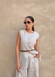 Woman wearing sleeveless sandy linen vest with front buttons and tailored fit